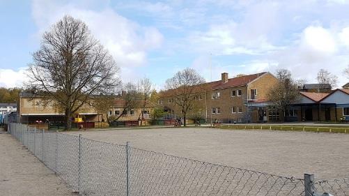 består till stora delar av en skolgård med gräsytor,