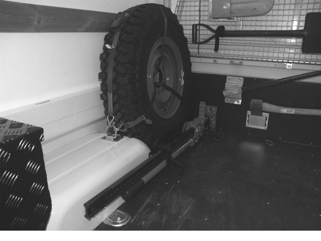 Konstruktion och funktion Lastterrängbil 1T, Flak 2M, 4x4 Domkraft Fordonet har utrustats med en extra domkraft som är placerad på flaket. Den är fastspänd med spännremmar. Bild 21.