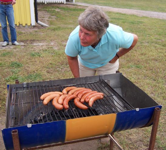 T.v. Eva Björling grillar korv under Skyttets dag T.h.. Kanske en framtida mästare provar luftgevärskytte på Skyttes dag.
