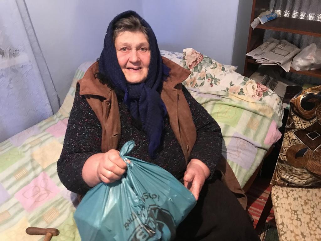 Ulyana Tjajka, heter damen som sitter i sin säng med ytterkläderna på.