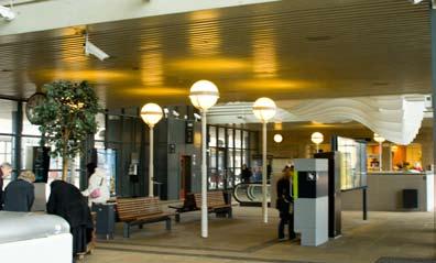 Banhallsformen syns tydligt på håll Platsbildning med handel Bro med trappor vid andra sidan Som passagerare leds jag direkt från perrongen till