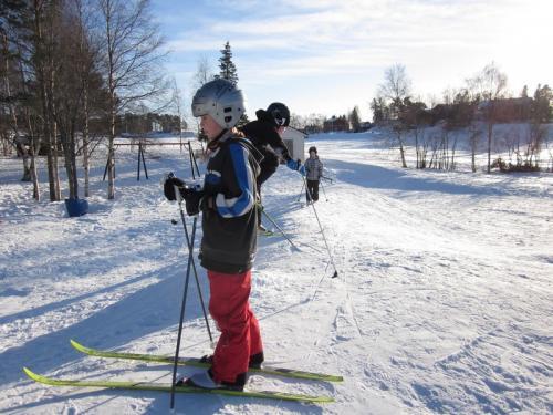 Skidor i backe. Förskolebarnen åker skridskor.