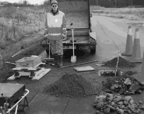 VÄRMEFORSK Figur 3. Provgrop i sträcka 5 med fältsiktat förstärkningslagermaterial av naturgrus. Strax vänster om vägmitt på den enkelriktade provvägen. (Foto: Maria Arm, 1998) Figure 3.