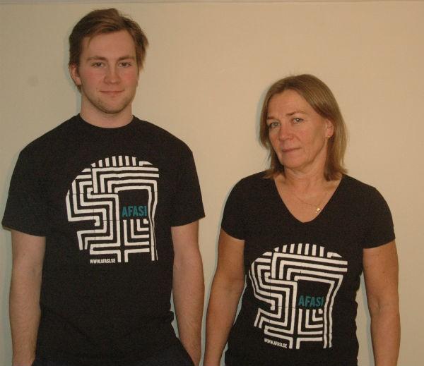 T-shirts och tygkassor designat av Mathilda Cederlund, Både t-shirt och tygkasse är svart med vit labyrint och turkosblå, text med ordet afasi tryckt på.
