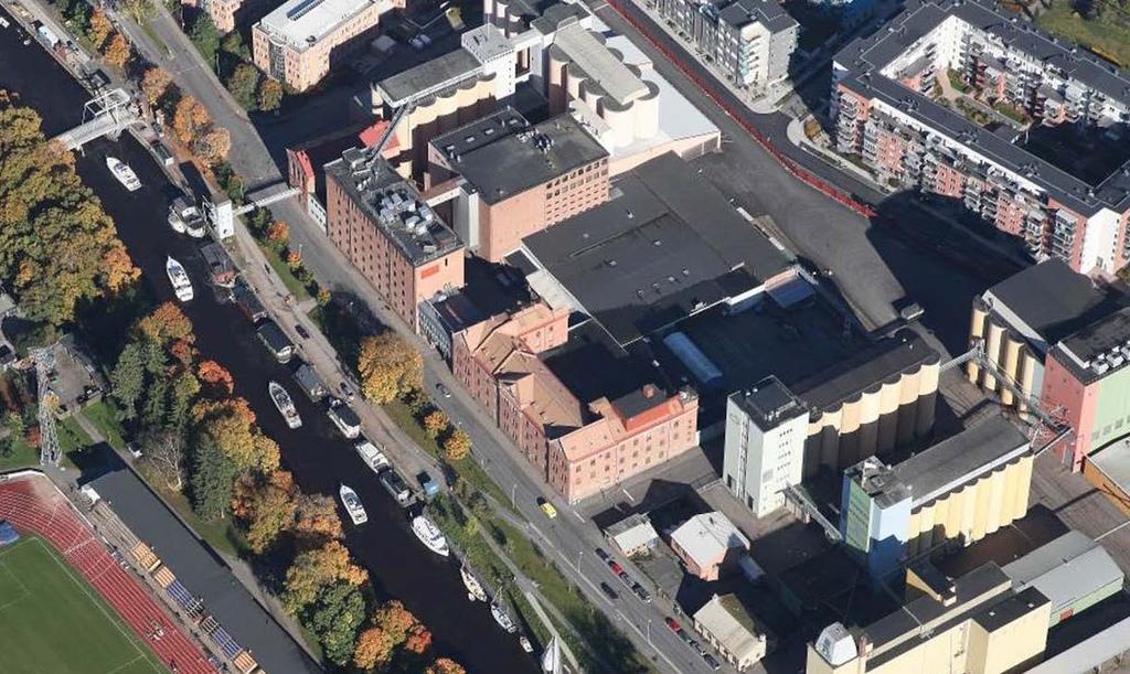 fasadlinje. Bakom dessa är en annan miljö med magasinsbyggnader, silotorn och asfaltsytor.