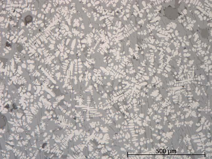 Slaggen är homogen även i mikroskala. Den består av dendritisk wüstit (ljus), olivinlameller och glas (två grå faser). De runda grå ytorna är hålrum. Figur 15.