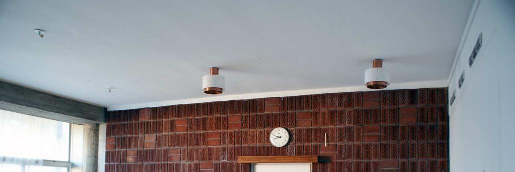 vitmålade originalfönster. Obehandlade betongpelare är synliga tillsammans med breda balkar av samma karaktär och kulör.