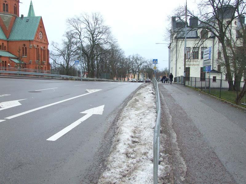2014-02-11 Som fotgängare så har man relativt god sikt åt båda håll. Intill vägkanten vid övergångsstället, ser man fordon från stationshållet ända ner till spåröverfarten 170 m längre bort.