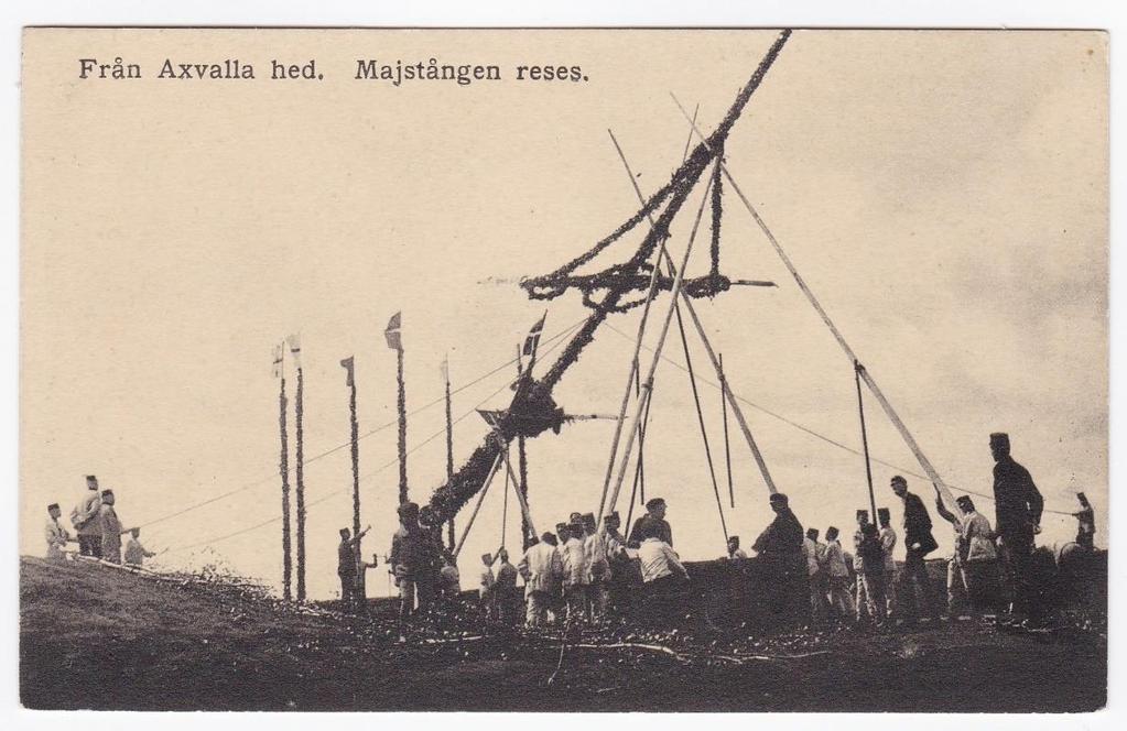 En midsommarhälsning från Axvall Från Axvalla hed. Majstången reses. Ofrankerat och oskrivet vykort utgivet av Otto Sellmans förlag, Axvall.
