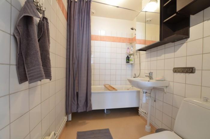 Badrum Halvkaklat badrum med platsmatta på golvet.