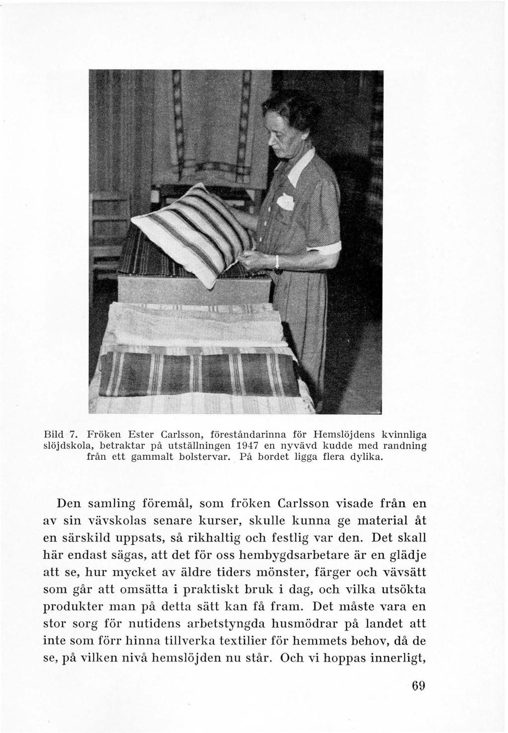 Bild 7. Fröken Ester Carlsson, förest åndarinna för Hemslöjdens kvinnliga slöjdskola, betraktar på utställningen 1947 en nyvävd kudde med randning från ett gammalt bolstervar.