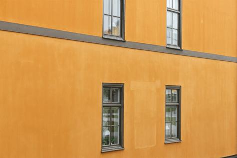 Igenputsade äldre fönsteröppningar, färgen har inte blivit lika mättad som övriga fasadytor Listverk/väggband har avfärgats med kalkfärg i kulör 6005 Y20R, detta är samma kulör som man målat