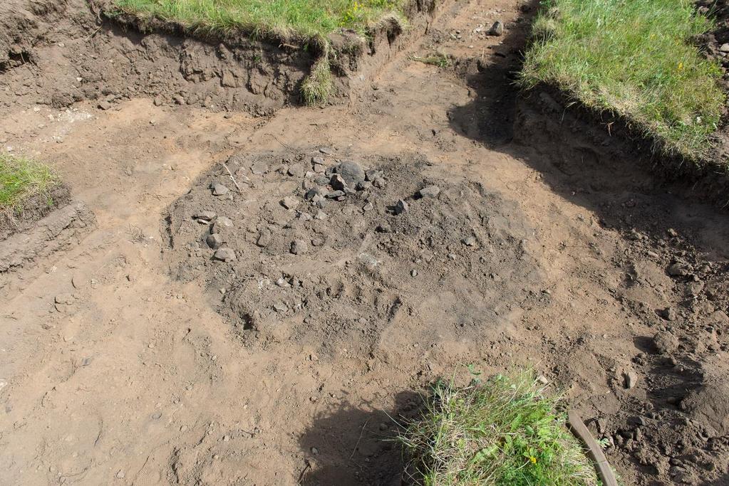 Schakt 6 Anläggning 1, mindre kolfläck direkt i sandlagret. Fläcken var ca 0,2 m i diameter och 0,03 m djup och återfanns på nivå 51,75, inga fynd.