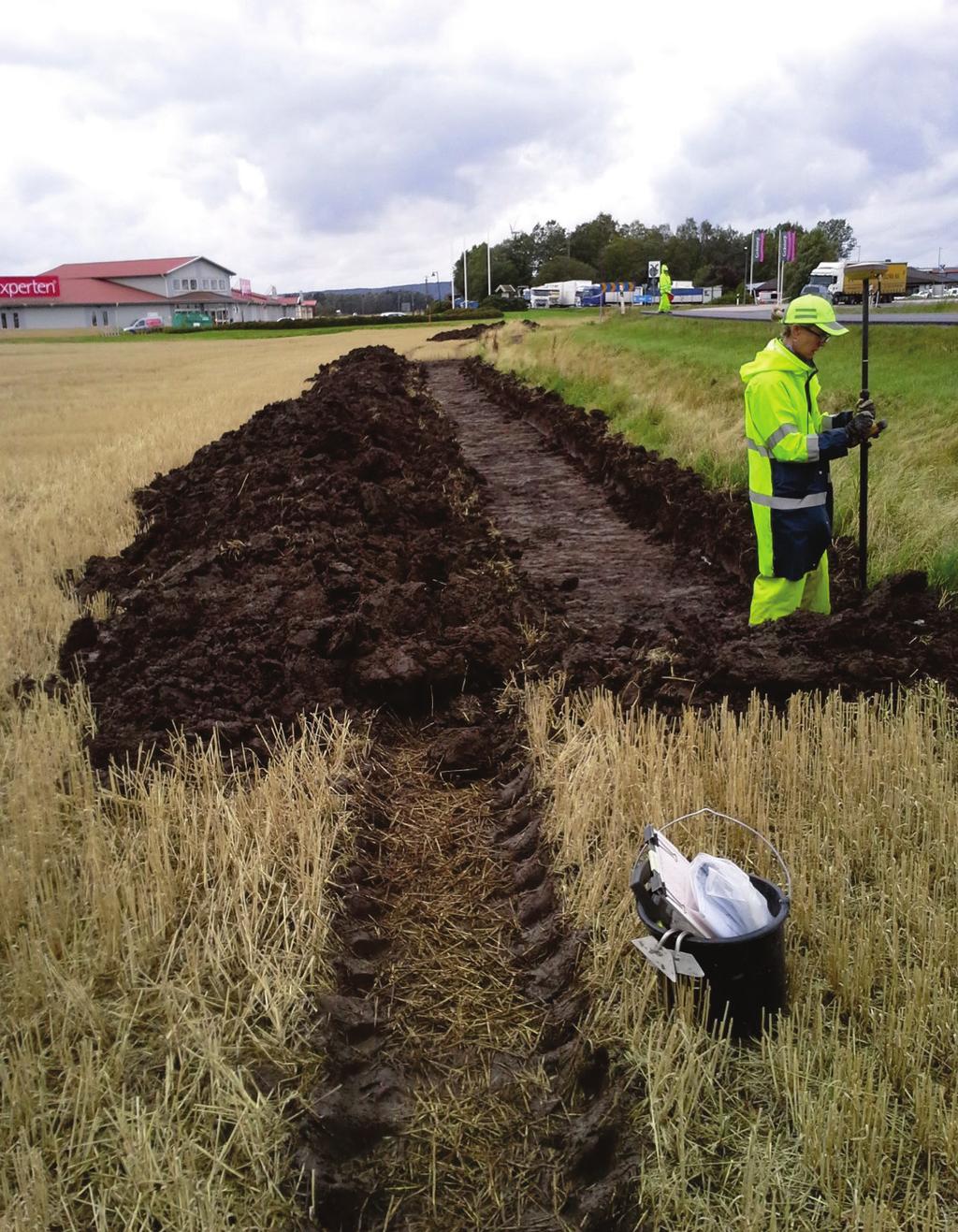 Fig. 6. Inmätning av schakt 18, schakt 19 i bakgrunden, foto från öst.