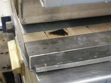 Fukt som ansamlas på ämnets yta medför överslag mellan aluminiumplåt och dragplåtens mothåll (horisontellt överslag), figur 8b. Figur 8.