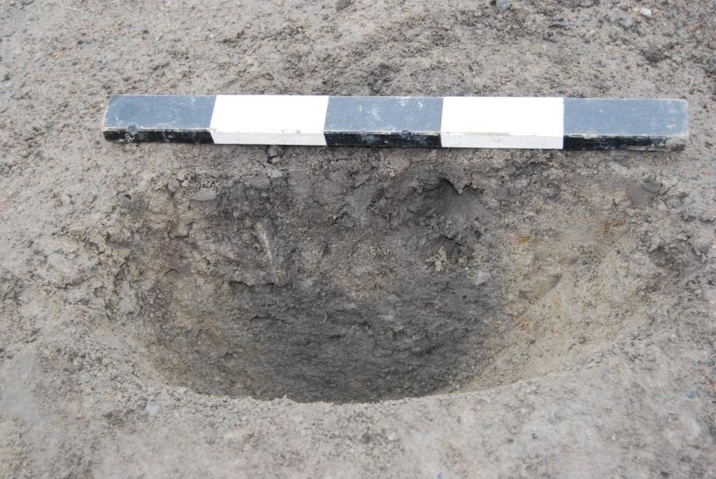 Litet ovalt stolphål med ojämna sidor och botten. Hålet hade följande mått: 35x30x13 cm. Det fylldes av en mörkbrun siltig sand och lite småsten under 2 cm i diameter.