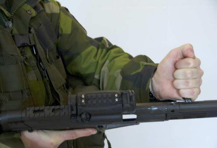 Vapnet hålls om pistolgreppet i ofarlig riktning med pekfingret utanför varbygeln. Patron ur 1.