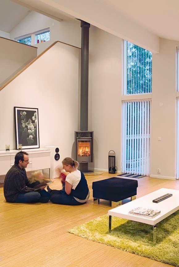 Iklätt sin mustigt svarta fasad i finsågad gran, poserar huset bland kala trädkronor och livliga höstfärger.