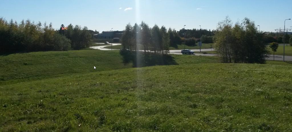 Figur 3. Vy mot sydväst från planerat ÅVC-område. Jordvall mot Bärbyleden, i bakgrunden E4:an. Figur 4. Vy mot söder från planerat ÅVC-område. Jordkullar i förgrunden, i bakgrunden Råbyvägen. 2.