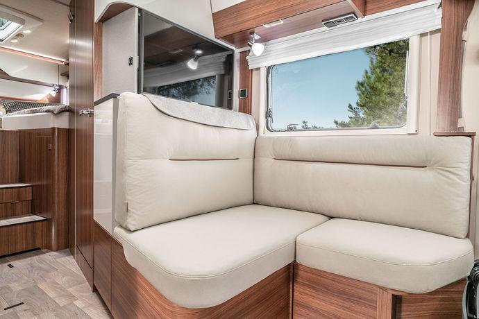 Soffgruppen i HYMER B-klass ModernComfort 580 här avbildad med möbeldekoren Noce Cognac (på önskemål, utan tillägg) kombinerat med klädseln Delfi (standard).