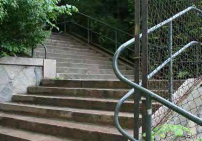 Kungsklippan. På två av trappans vilplan står parksoffor och längs båda sidor av trappan finns buskplanteringar.