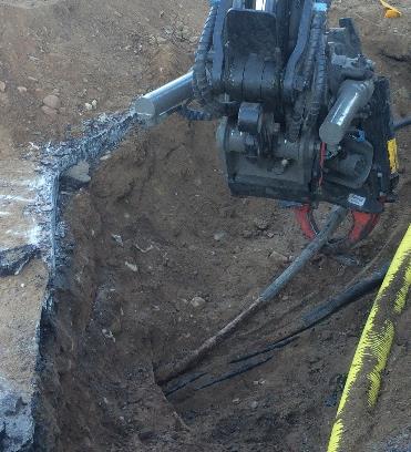 Figur 14 Kabel lyfts upp med grävlastarens klo i kortare sektioner På en del ställen fanns det något ovanför kabeln vilket gjorde att det inte gick att frilägga den fullständigt.