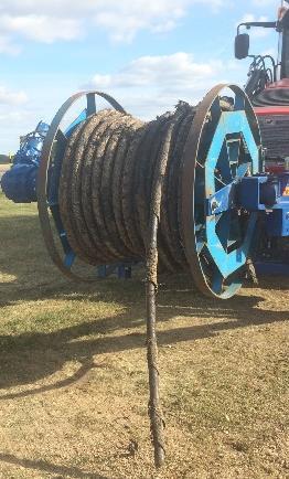 Kabeln fästes i ställningen, eller i de fall en bit kabel redan var upprullad, i änden på den kabeln. Därefter stod grävlastaren still och kabeln drogs längs med marken medan den nystades in.