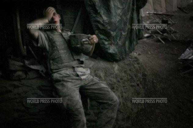 AsoldierofSecondPlatoon,BattleCompanyoftheSecondBattalionoftheUS503rd InfantryRegimentsinksontoanembankmentintheRestrepobunkerattheendofthe day.