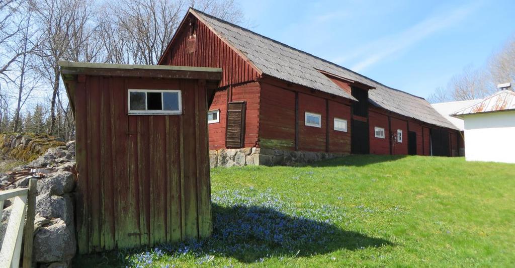 Traditionell ladugård i skiftesverk och utedass