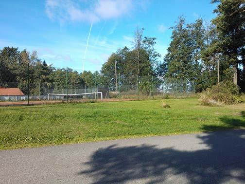 Näkymä koillisesta; vanha saunarakennus sekä urheilukentän pohjoispäädyn aitaus.