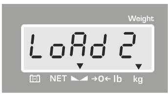 När "LoAd 2" indikeringen visas ställ försiktigt upp den andra justeringsvikten i mitten av vågplattan.
