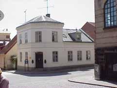 Markant tegelklätt skärmtak över entrén, som är framdragen, och garagenerfarten.