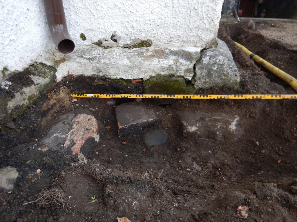 Fig. 4. Fotot visar de blottade grundstenarna i schakt 1. Foto mot öster. kunde anas som två parallella mörkfärgningar. Graven låg i princip i öst-västlig riktning. Graven fotodokumenterades, se fig.