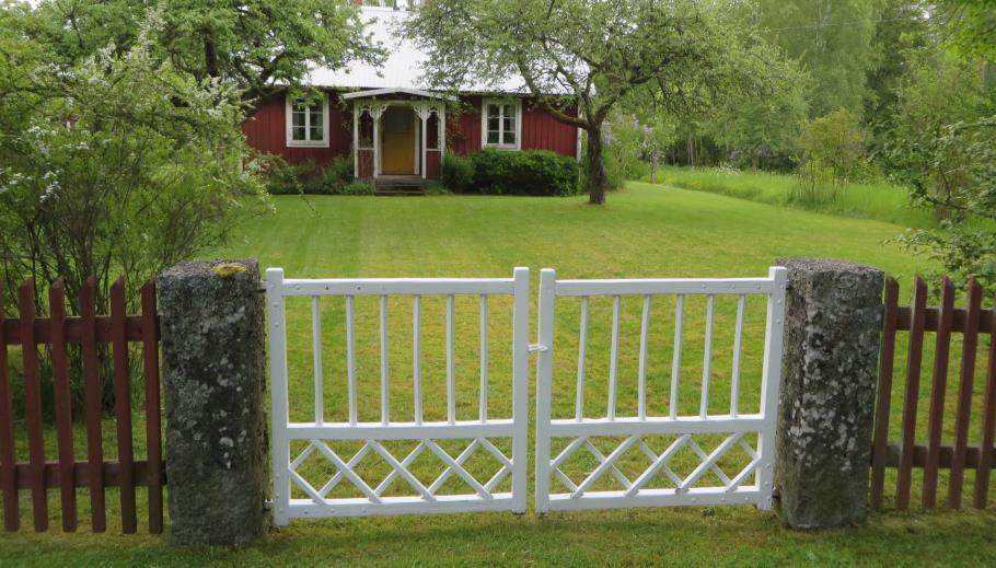En mindre gård (bostadshus 1895) med traditionellt staket med