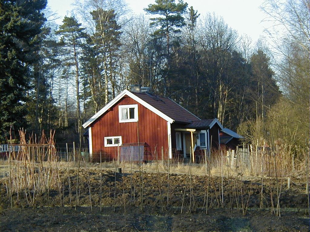 Lägenheten Loviselund från söder, i förgrunden skymtar en del av odlingslotterna. Låg efter gamla häradsvägen mellan Västerhaninge Prästgård och Jordbro/Kalvsvik, på höger sida, efter odlingslotterna.