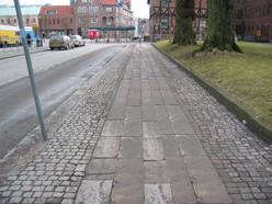 Förslagsvis plattor för gående och asfalt för cyklister. Gångbanan bör vara 1,5 2 meter bred. I korsningar och infarter, exempelvis parkeringsplatser, bör taktila och visuella ledstråk finnas.