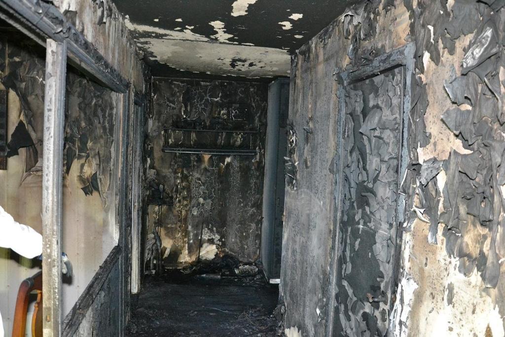 Lägenhetskorridoren med hall och hatthylla/klädhängare i bakgrunden.