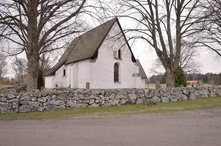 Västeråkers kyrkogård från väster med två av de lindar som planterades på 1910-talet när hela trädkransen byttes ut. renner och häggmispel.