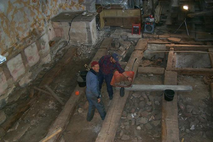 Fig. 9. Här syns klockaren i Bro, Otto Andersson, och arkeologen Magnus Stenhols i färd med att undersöka Bro kyrka. Till höger snett bakom dem syns gravkammaren i östra delen av långhuset, mot koret.