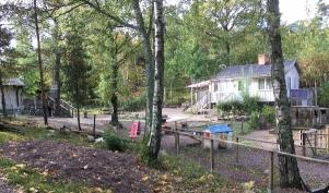 barnen är utomhus (bild 2). Den sydöstra delen av tomten öppnas mot en allmänning/grönområde, s.k.
