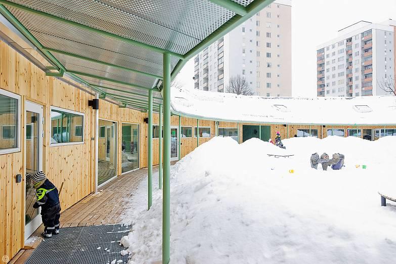 Träet i fasaden som vetter mot innergården ger en mjukare och varmare känsla, takutsprånget som går runt hela innergården ger också en inneslutande känsla.