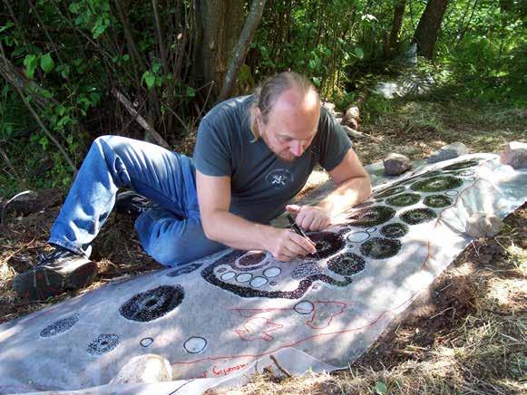 Fig. 16. Tommy kalkerar Bro 703 på genomskinlig plast med dutt-teknik. Djupare är ristningar blir svartare än grunda. Tommy traces Bro 703 on transparent plastic with a 'dabbing technique'.