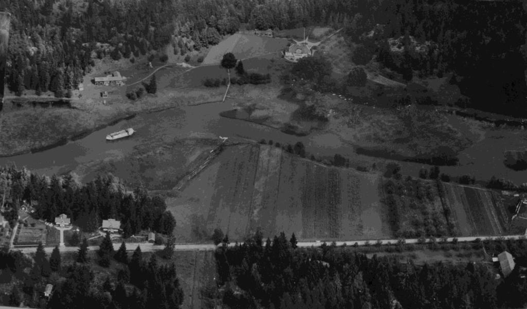 (Bild 8) Flygfoto över Vårgård 1931 med Hjulsbrovägen (idag Uvebergsvägen) i nederkant. På kanalen syns motorlastfartyget REX av Linköping.