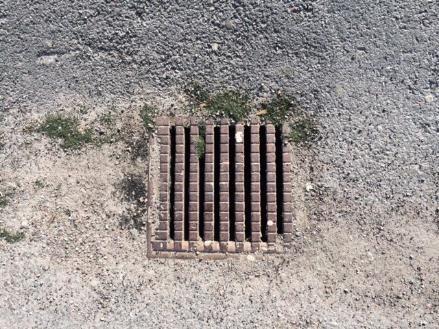 Dagvattenbrunn på Stadshagens IP. De små svarta prickarna är granulat och det gröna är plastgräs. Foto: Jenny Fäldt.