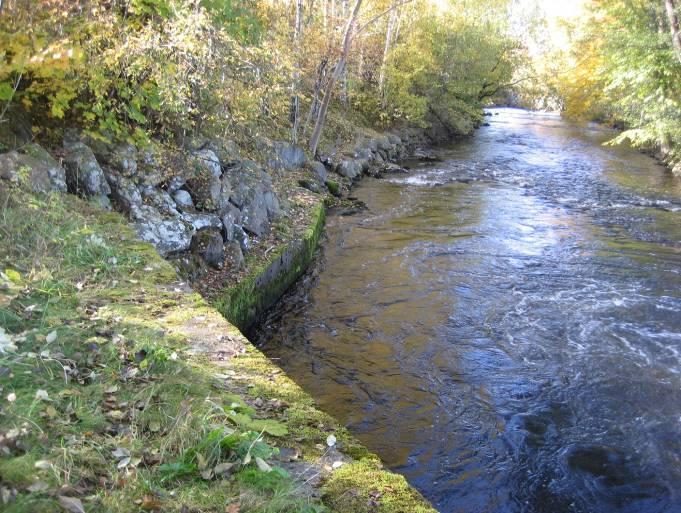 3.5.3 Nedströms dämmet Nedströms dammen är sektionsbredden normalt ca 10 m men bitvis något större. Kanalbotten utgörs av sten av varierande storlek. Den genomsnittliga bottenlutningen är drygt 4.