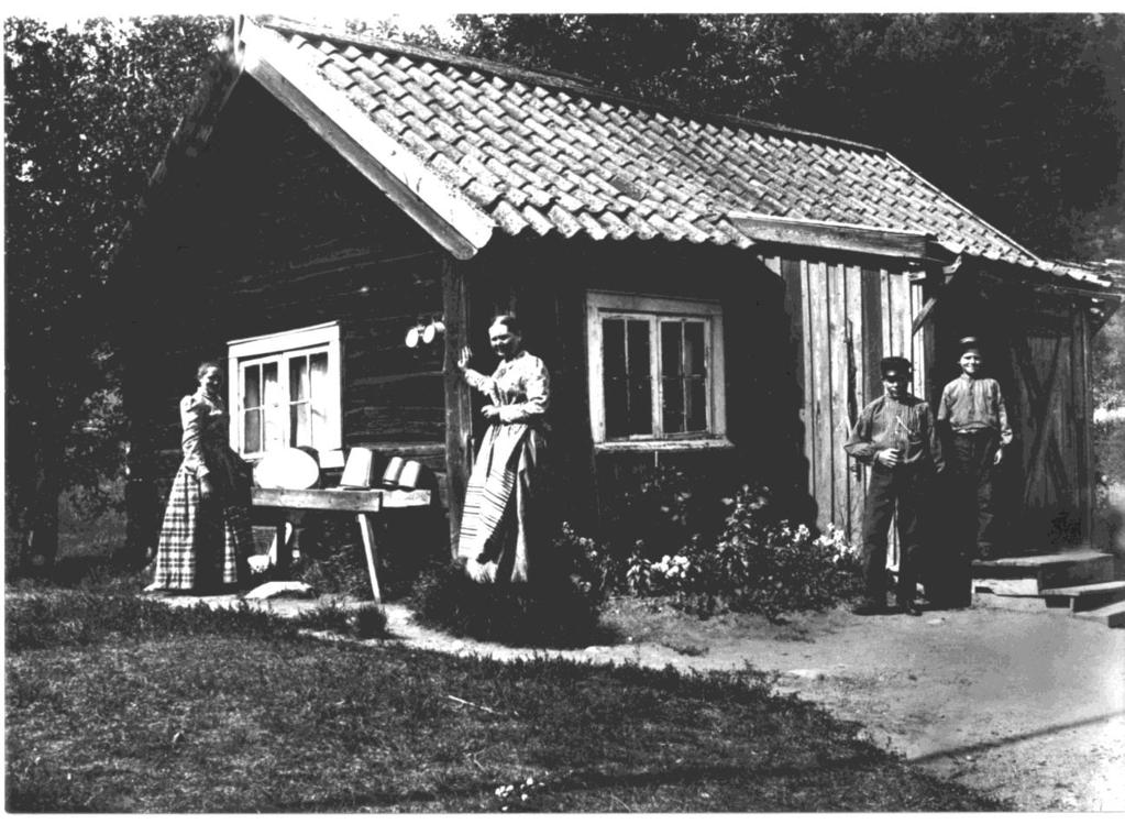 Hur ett 1800-talstorp i Tutviken blir hemman och så småningom en 2000-talsbostad. Foto från 1896. Vid hitre hörnet står Maria Rosing, vid dörren Wilhelm och Karl.
