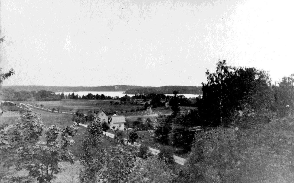 Foto taget från berget ovanför huset på Oxhagsvägen 6 omkring år 1910 I förgrunden ses träden på Magnussons tomt, och den sträckte sig en bit hitom de vita byggnaderna.