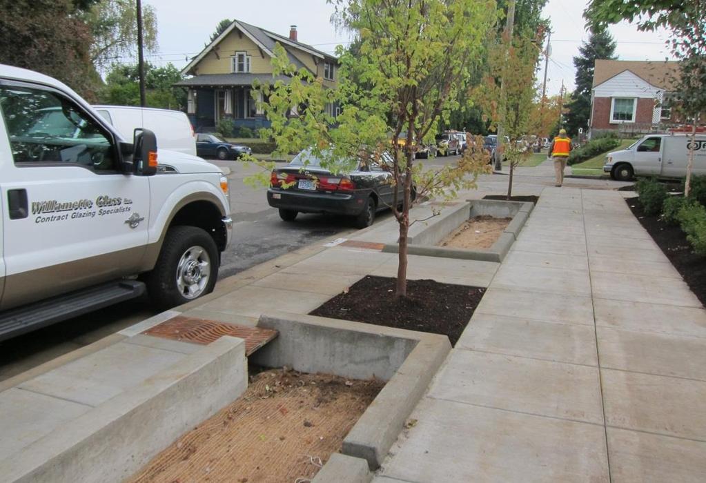 En plantering eller trädrad mellan väg och trottoar kan göras med nedsänkta planteringar eller gräsytor.