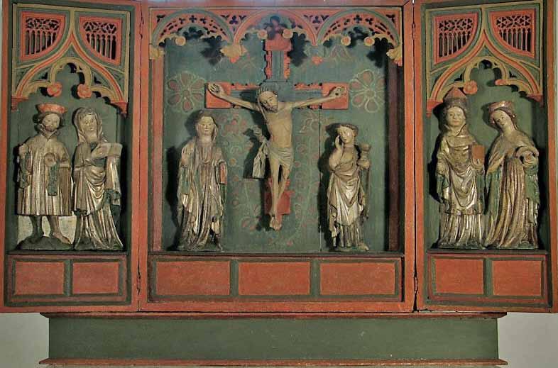 På väggen i koret finns en överdel till altaruppsatsen. Den föreställer Lammet som vilar på en bok.