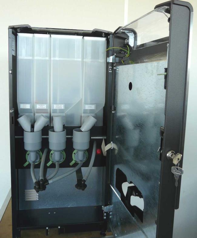 2 Beskrivning av maskinen 2.1 Allmänt Maskinen är en kompakt halvautomatisk maskin för tillagning och servering av heta drycker. Din leverantör kan justera smak och storlek på dryckerna. 2.2 Maskinens framsida Maskinen kan användas med hjälp av driftspanelen på dörr.